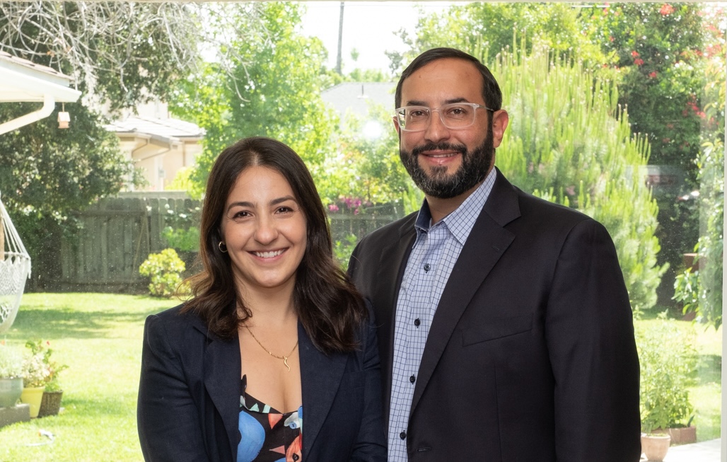 A home with a beige-painted front door, featuring a silver handle and a black relock padlock on the right.